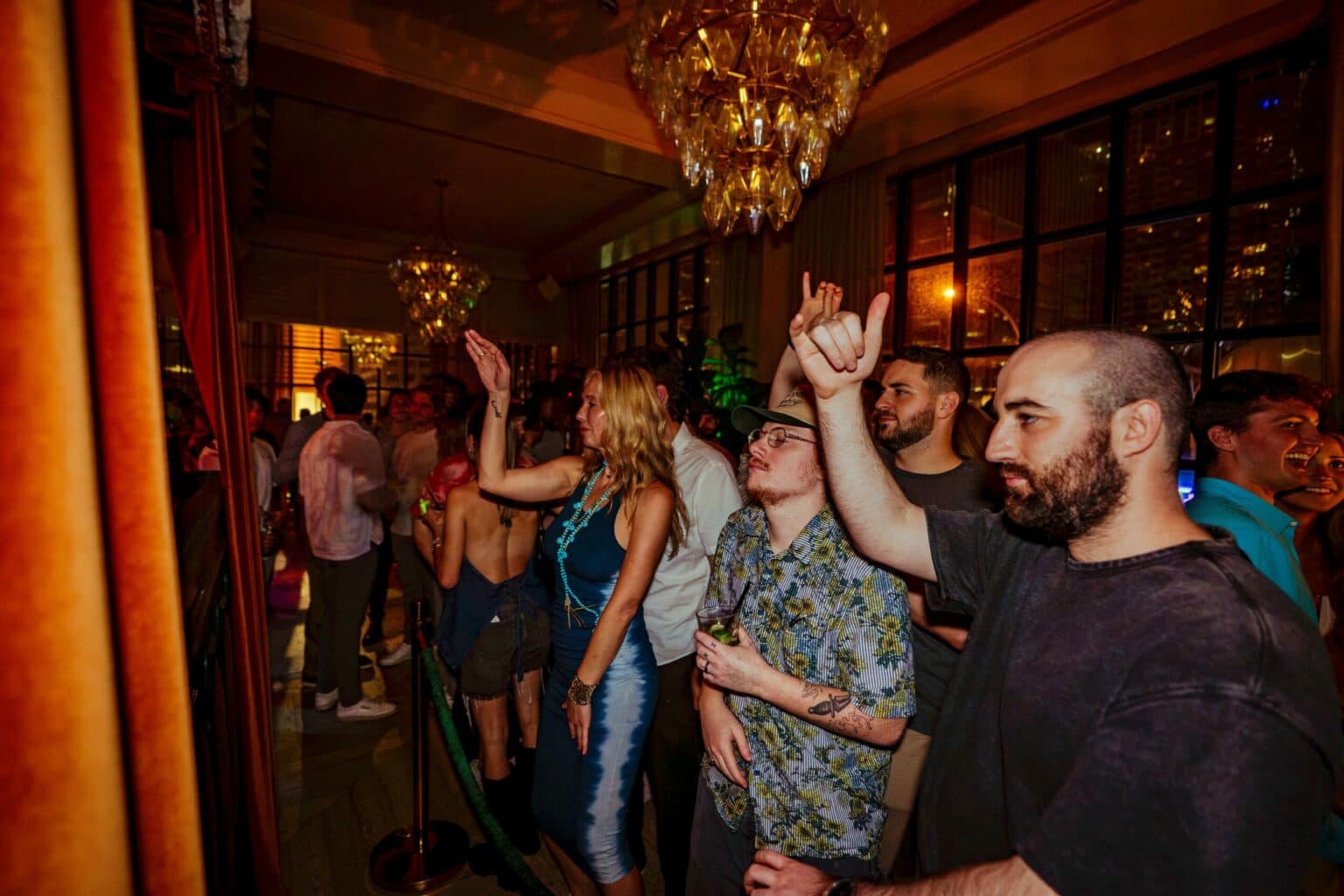 A First Reef nightlife event — a crowd dancing under chandeliers at a Miami lounge